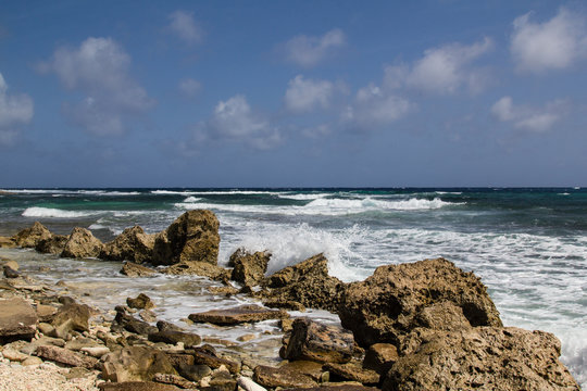 Wild and high waves rolling in at the rough and rocky shoreline of the east coast of the island of Bonaire in the caribbean