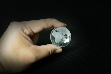 The glass ball planet earth and hand image.