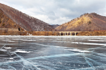 Lake Baikal in winter. Historical Circum-Baikal Railway. View from the ice on the stone arched bridge (1904) over the Angasolka River
