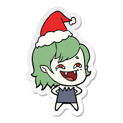 sticker cartoon of a laughing vampire girl wearing santa hat