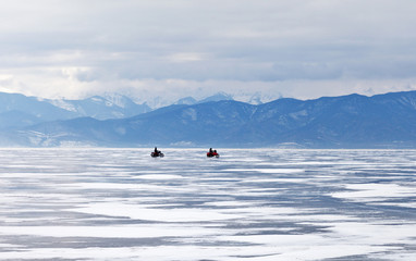 Lake Baikal in winter. Local residents are fishermen go by motorcycles on the ice of the lake for fishing in the early morning