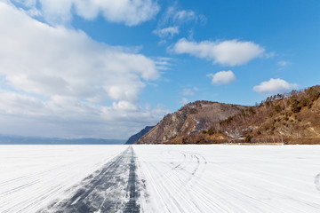 Lake Baikal. Winter road on the ice of the lake along the Circum-Baikal Railway. Traveling by car on the ice of the lake