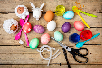 Flatlay, Basteln an Ostern, viele Bastelutensilien, Ostereier und Farben auf Holz