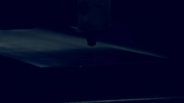 Modern programmed robot head cuts metal with sparks.