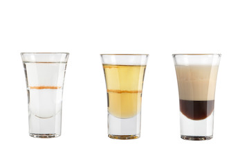 Set of alcohol shots on a white background. Three shots with different types of strong alcohol.