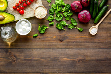 Fresh organic vegetables on dark wooden background top view copy space. Kitchen desk for preparing salad