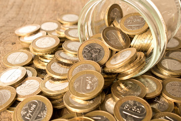 Coins scattered on a wooden table. The concept of capital increase.