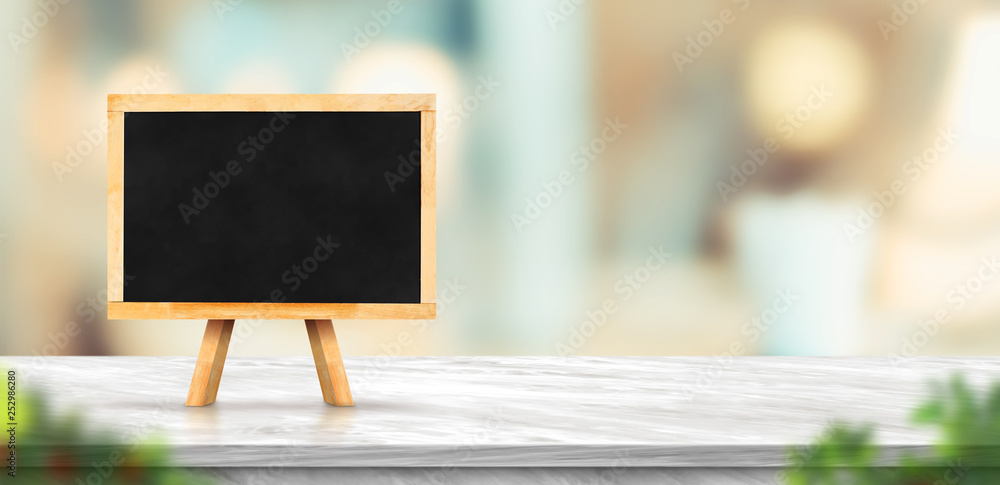Aufkleber blackboard on white marble table and blurred soft light table in luxury restaurant with bokeh backgr