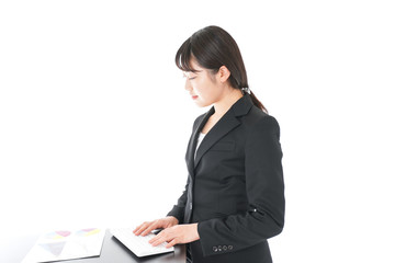 立ってデスクワークをする若いビジネスウーマン