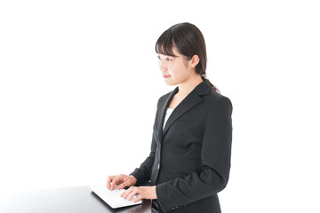 立ってデスクワークをする若いビジネスウーマン