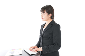 立ってデスクワークをする若いビジネスウーマン