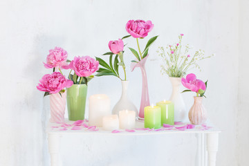Fototapeta na wymiar flowers in vases and candles on white background