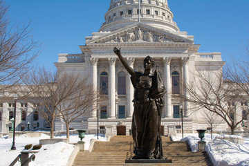 Fototapeta na wymiar Statue and Capital Building