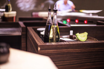 Japanese shoyu soy sauce and Olive Cooking Oil in glass bottles ready for chef to use in Japanese restaurant kitchen. Cooking, Food Recipe, Ingredient Container, Hygiene, Cleanliness, Tidiness concept