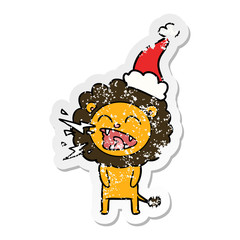distressed sticker cartoon of a roaring lion wearing santa hat
