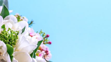 A bouquet of tulips and decorative flowers close-up on a blue background. Place for text.