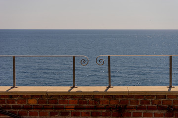 Italy, Cinque Terre, Manarola, a close up of a bench in front of a body of water