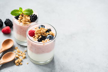Berry yogurt with fresh berries and granola in jar. Greek yogurt, healthy breakfast parfait in glass cup. Copy space for text