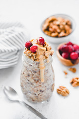 Overnight oats with berries and nut butter in jar. Healthy breakfast. Vegan, vegetarian and weight loss diet concept