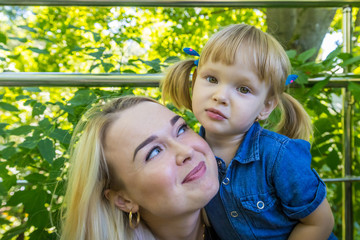 Cute blonde woman and her daughter in the park