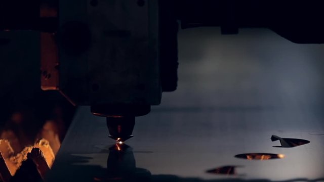 Laser cutter. Industrial cnc plasma cutting of metal plate. Industrial laser cutting torch cuts preparations from metal. Modern industrial technology. Lot of bright sparks light. Slow motion video.