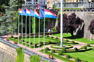 Fototapeta na wymiar Park in historical center of Luxembourg city and national flag.