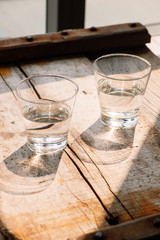 Two glasses of water on table on wooden background