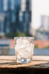 Glasses with ice cubes on wooden table