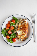 Omelet with mushrooms, salad with cherry tomatoes and spinach, on a light background. Healthy eating concept. Close-up.