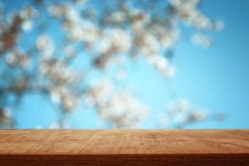 wooden table in front of spring blossom tree landscape. Product display and presentation