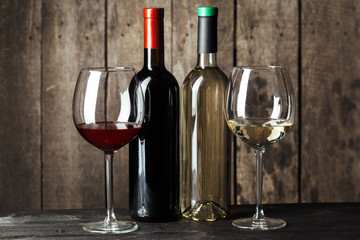 Wine bottles with glass, wooden background