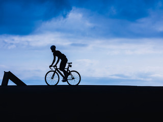 Fototapeta na wymiar Silhouette man on bicycle Cyclist fix gear riding outdoor