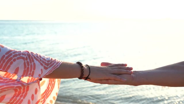 Arm stacked together one by one in unity and teamwork. Many hands getting together in the center of a circle. Close up outdoor shot. Many hands connecting in nature near sea water during sunset