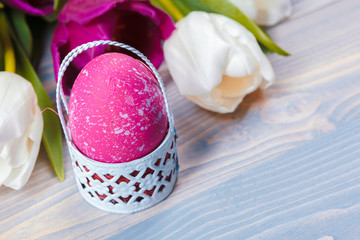 Easter eggs with tulips on blue wooden background