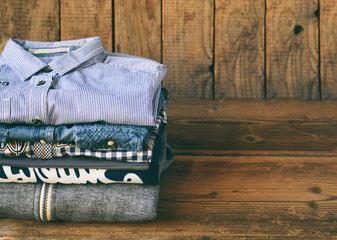 Teenager casual outfit. Boys shoes, clothing and accessories on wooden background - sweater, shirt. Top view. Flat lay