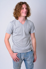 Portrait of happy young handsome man with curly hair thinking