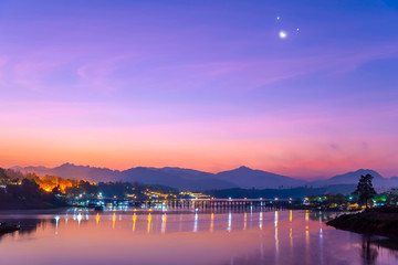 Old wooden bridge (Mon Bridge) in the middle of the river at sunrise, Kanchanaburi province, Thailand.