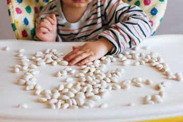 Young boy playing with beans. Be good for your fine motor skills
