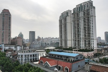 Fototapeta na wymiar Cityscape in Shanghai China with skyscrapers, high rise and low rise buildings, and houses on cloudy, smoggy grey day