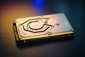 Hard disk on the table in dark colors and lighting close-up.