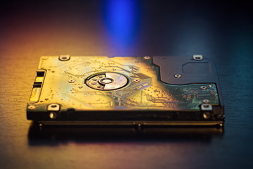 Hard disk on the table in dark colors and lighting close-up.