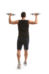 Fototapeta na wymiar Sporty young man training with dumbbells against white background
