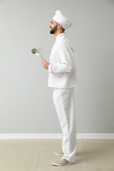 Male chef near light wall