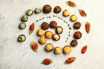 Tasty stuffed mushrooms on light wooden background