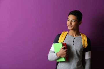 African-American schoolboy on color background