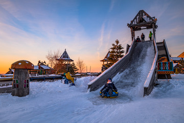children riding on the hill. winter activities in nature. guys having fun on the icy slide....