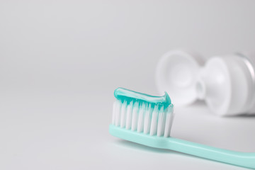 Toothbrush and toothpaste on blurred background