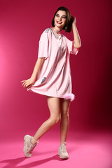 Fashionable young woman on color background