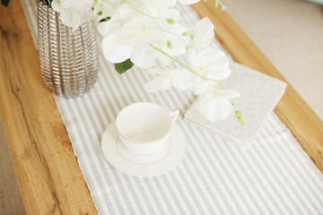 Light classic living room interior. coffee table and white orchid in vaz. A bright sunny day