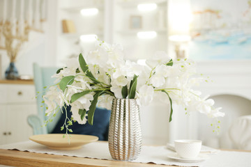 Light classic living room interior. coffee table and white orchid in vaz. A bright sunny day